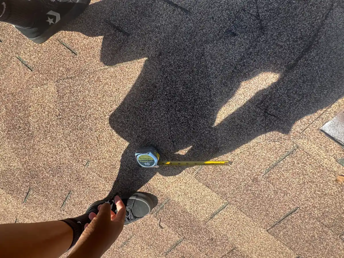Roof inspection shows a worker using a tool beside shingles, Southern Premier Roofing work near Lawrenceville GA