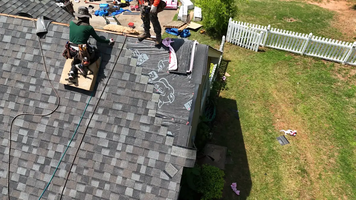 Roofers installing shingles around ridge vent and roof edge, Southern Premier Roofing work near Lawrenceville GA