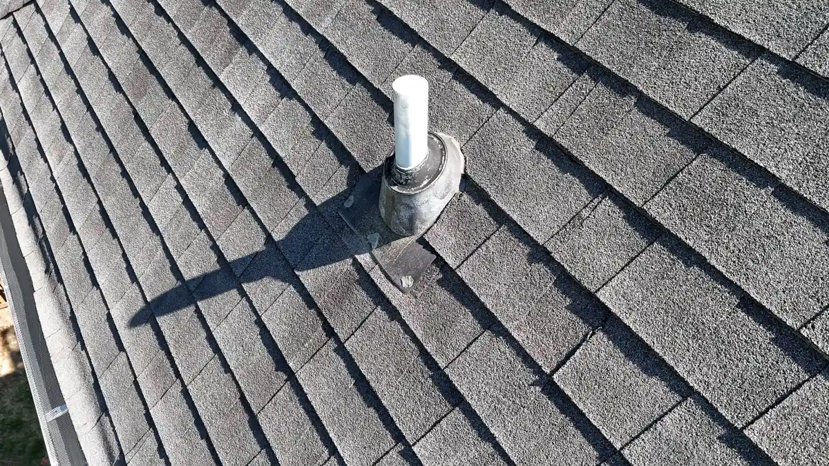 White vent pipe with flashing on overlapping asphalt shingles, Southern Premier Roofing work near Lilburn GA