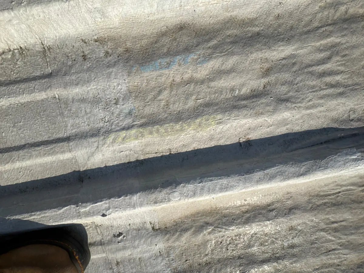 Close view of weathered roof panel seams and deteriorated coating, Southern Premier Roofing work near Lithonia GA