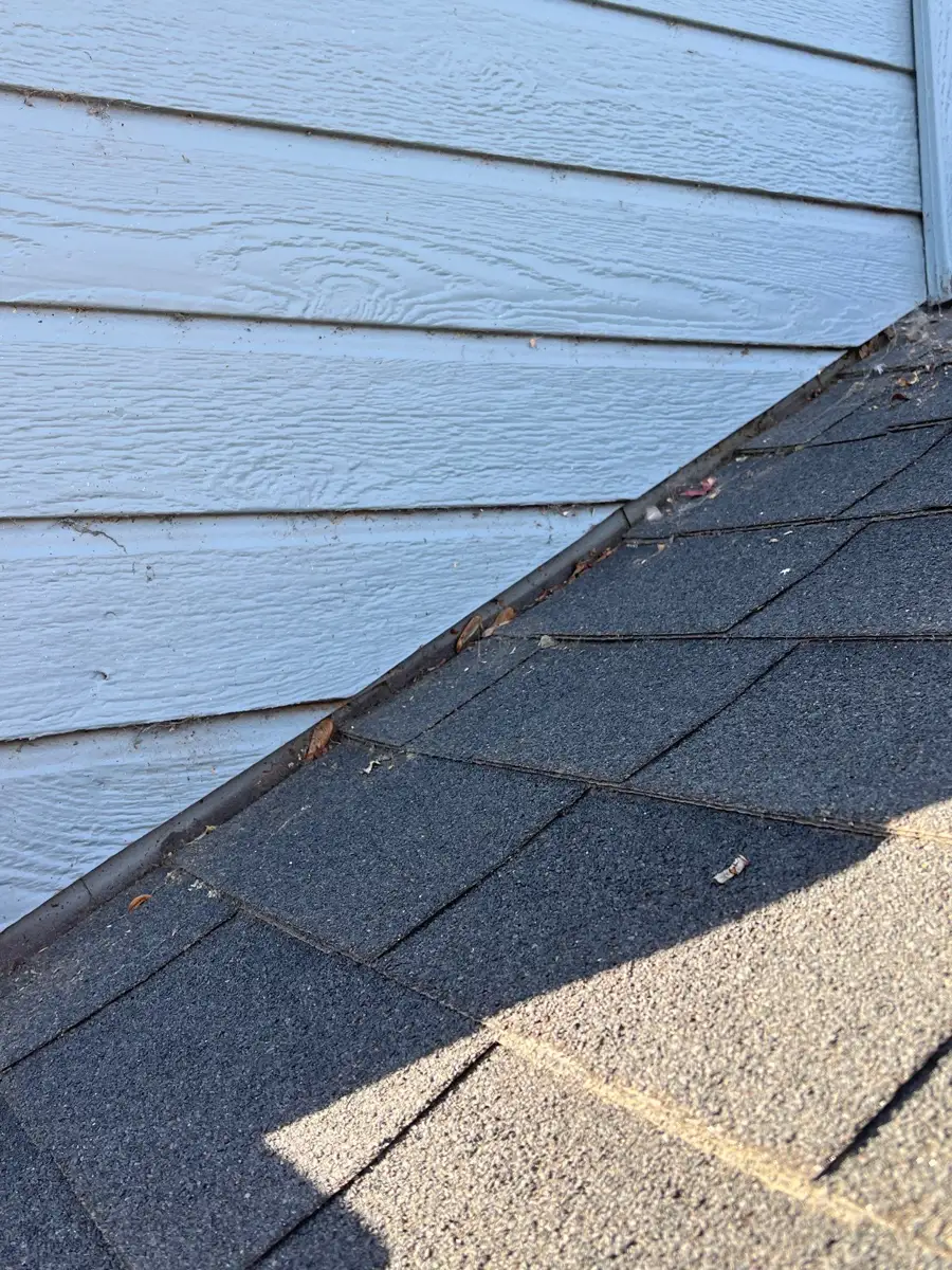 Roof-to-wall junction showing shingles and weathered flashing, Southern Premier Roofing work near Loganville GA
