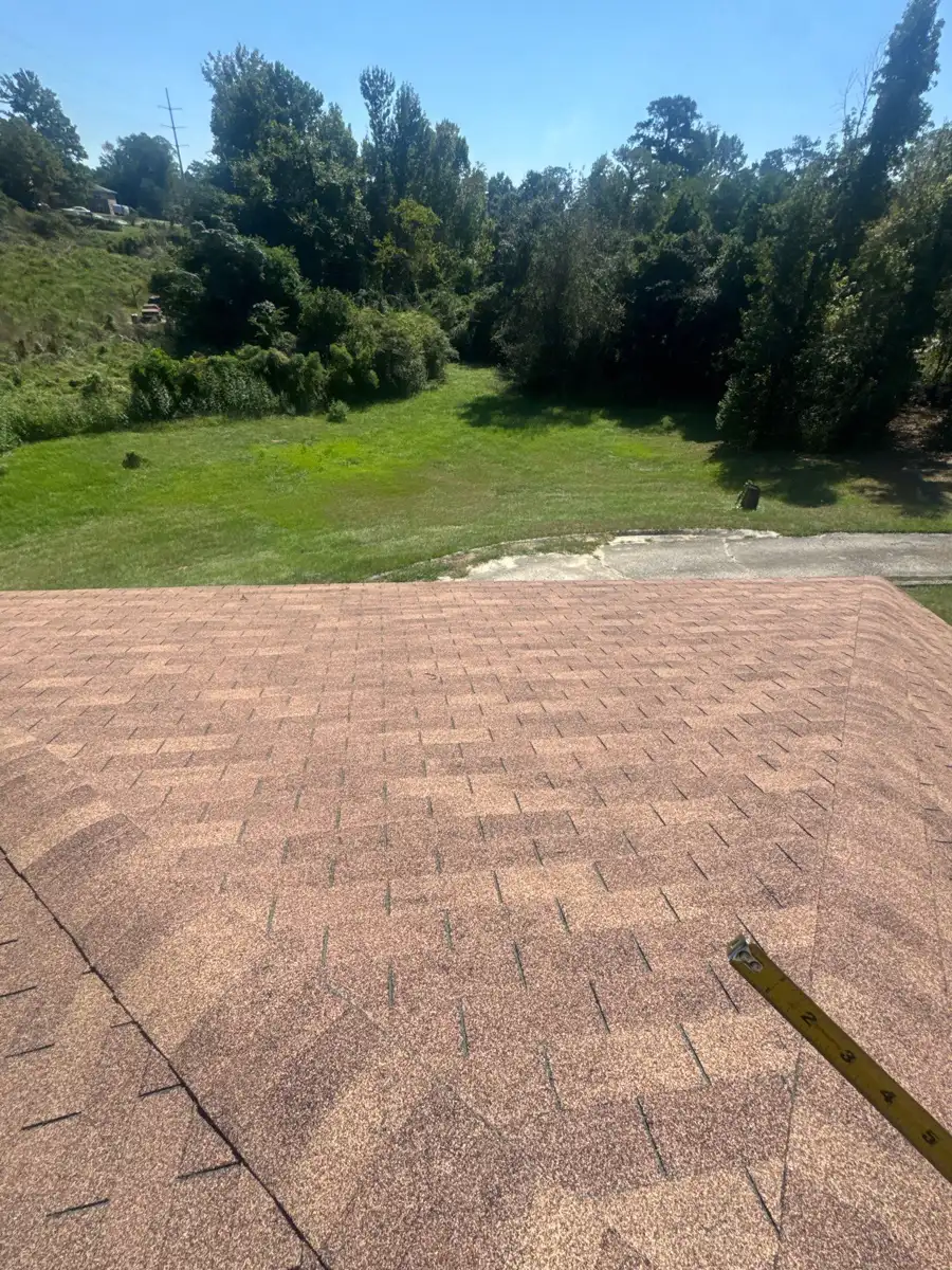 Completed shingle roof overlooks a green lawn and wooded landscape, Southern Premier Roofing work near Loganville GA