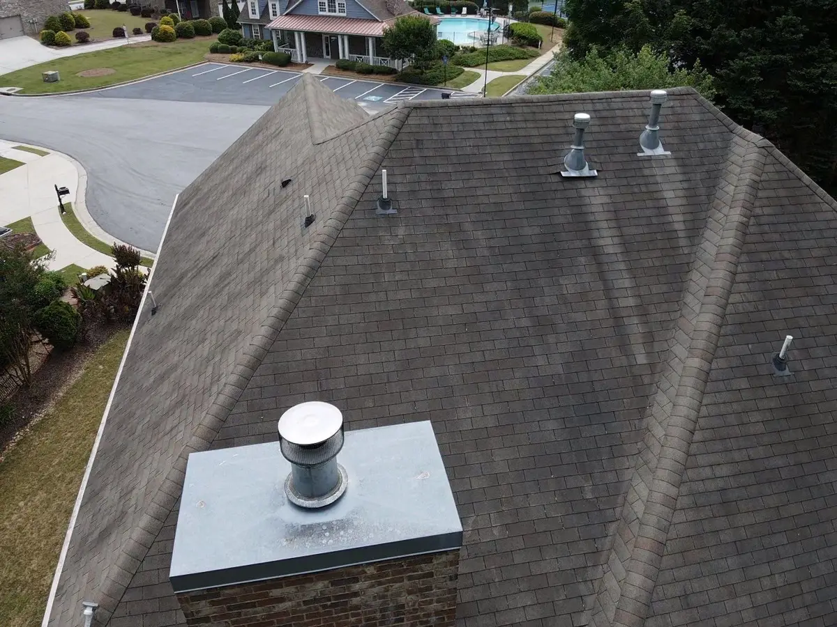 Completed roof with chimney flashing and multiple metal vent pipes, Southern Premier Roofing work near Monroe GA