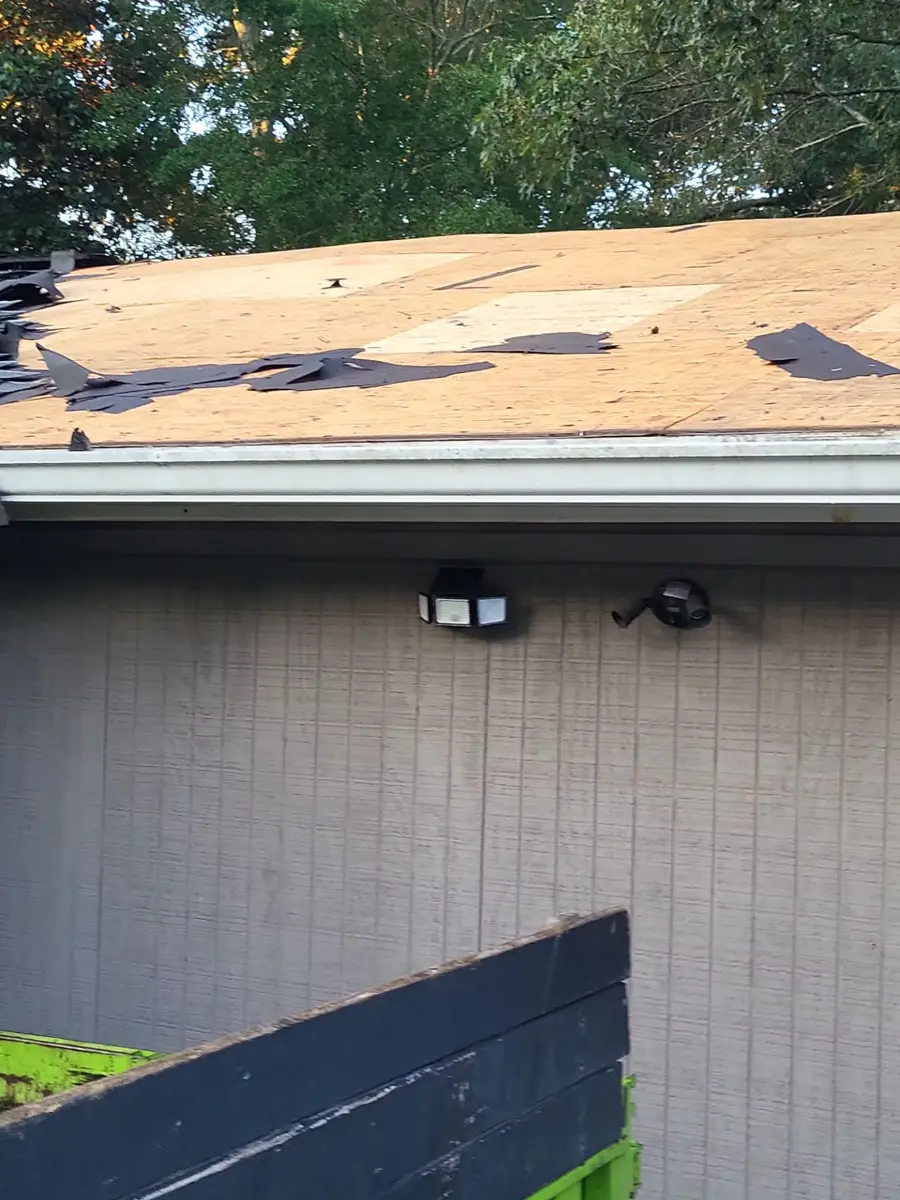 Roof deck exposed with scattered dark patches above exterior wall, Southern Premier Roofing work near Mulberry GA