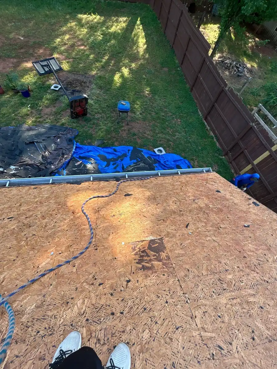 Roof deck with exposed plywood overlooking yard and equipment, Southern Premier Roofing work near Norcross GA