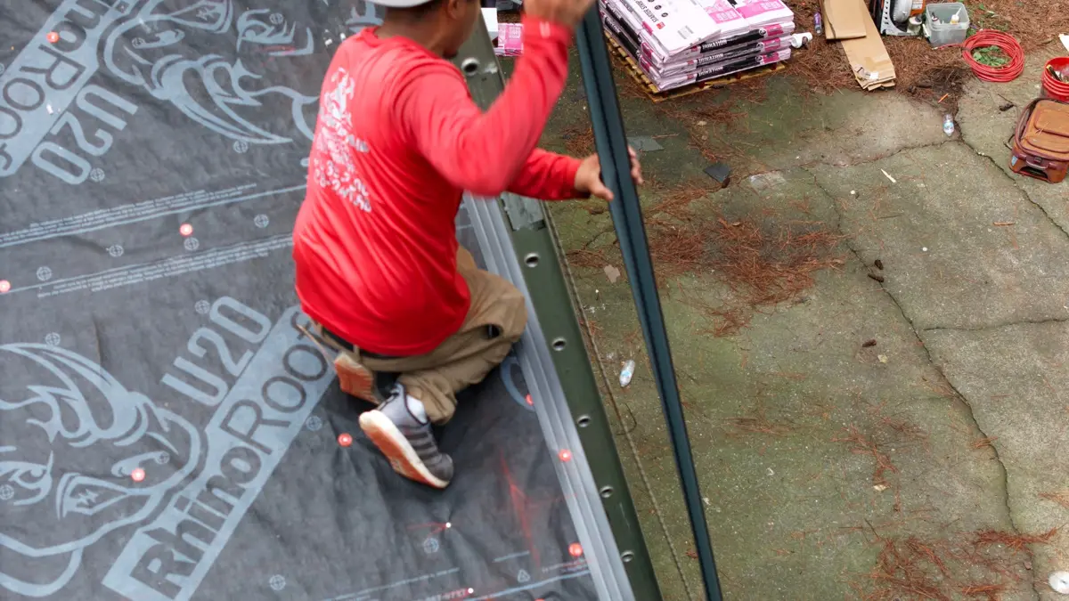 Worker installs roofing materials along an underlayment edge, Southern Premier Roofing work near North High Shoals GA