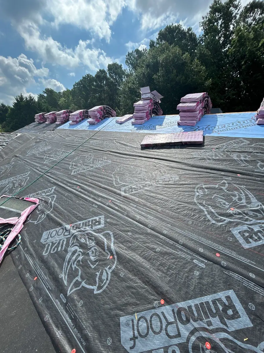 Roof covered with black underlayment and stacked pink shingle bundles, Southern Premier Roofing work near Oxford GA