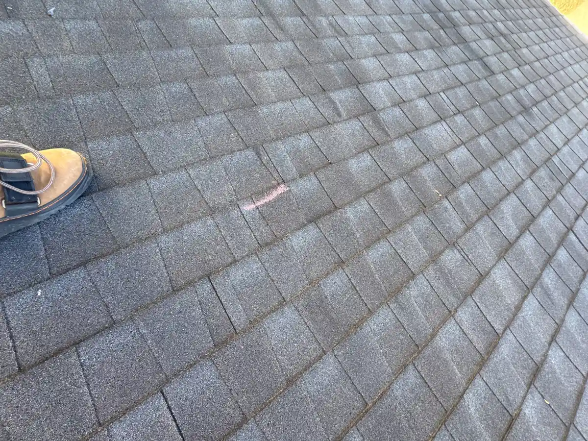 Close-up roof inspection showing marked shingle area and footwear, Southern Premier Roofing work near Pendergrass GA