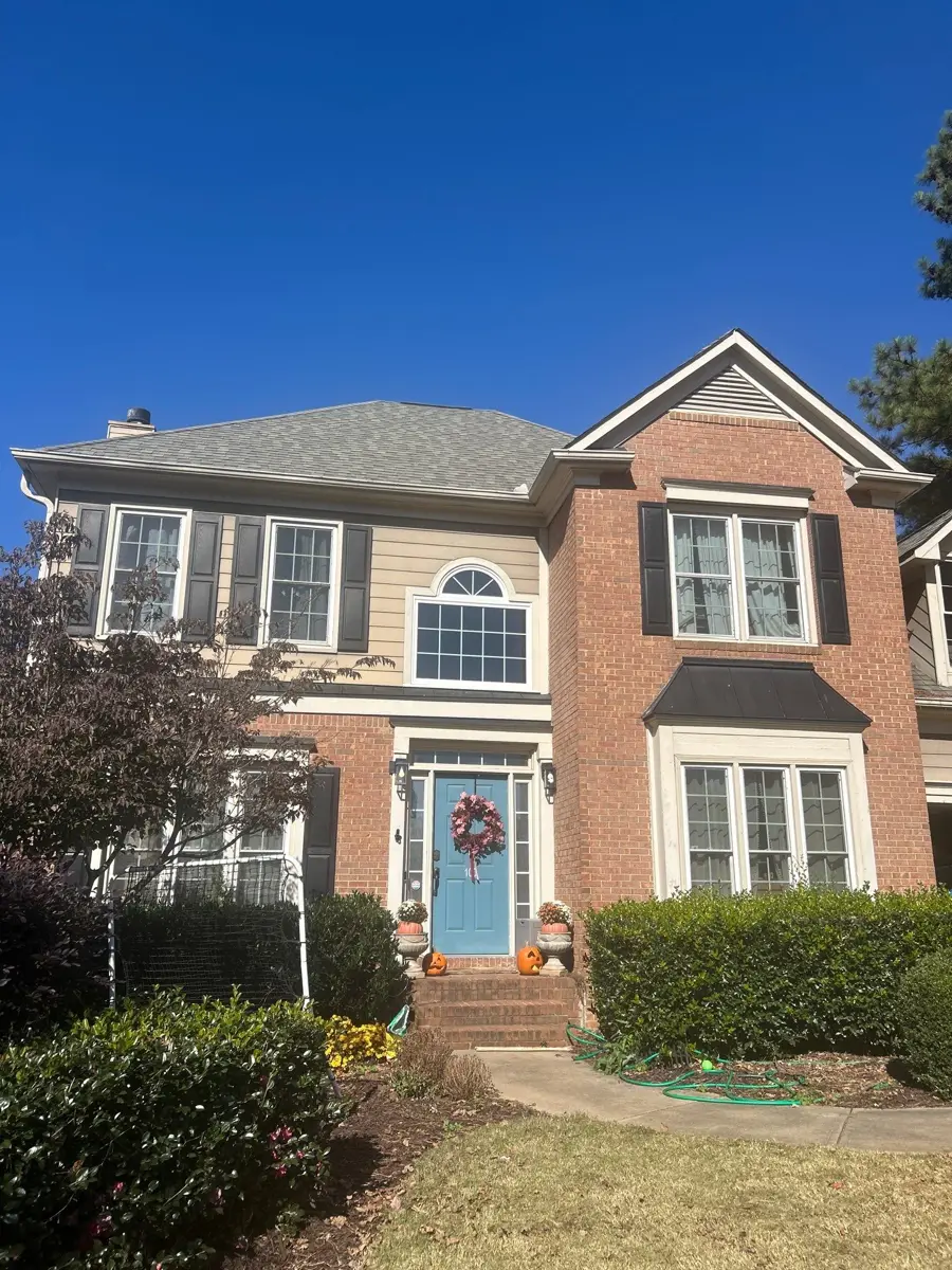 Front view of completed residential roof with brick facade and landscaping, Southern Premier Roofing work near Snellville GA
