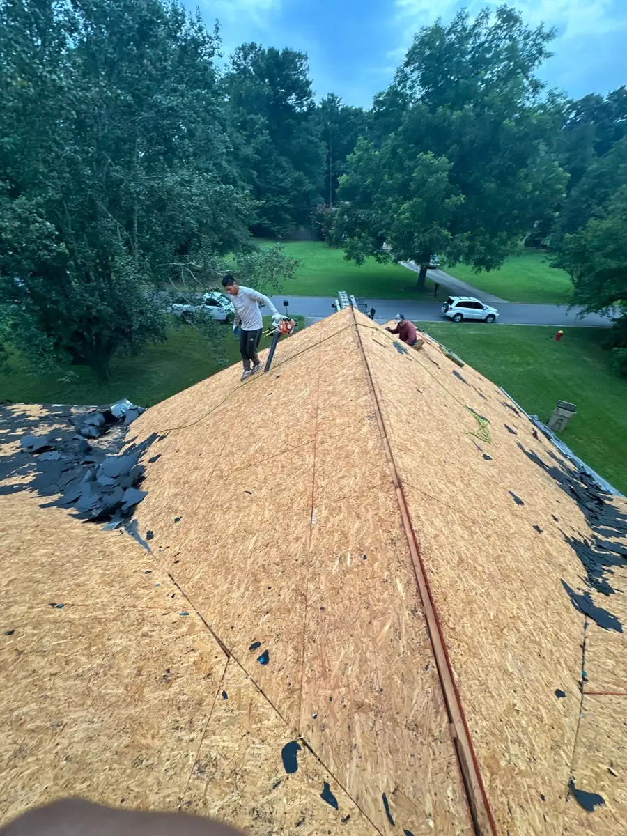 New roof decking spans ridge with workers and exposed roof edges, Southern Premier Roofing work near Social Circle GA