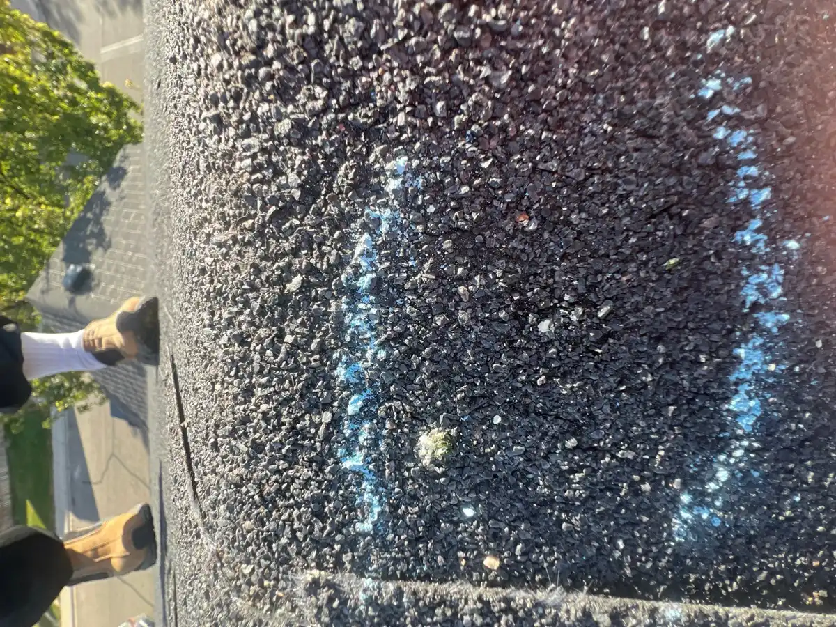 Close-up shingle surface with blue inspection markings and debris, Southern Premier Roofing work near Statham GA