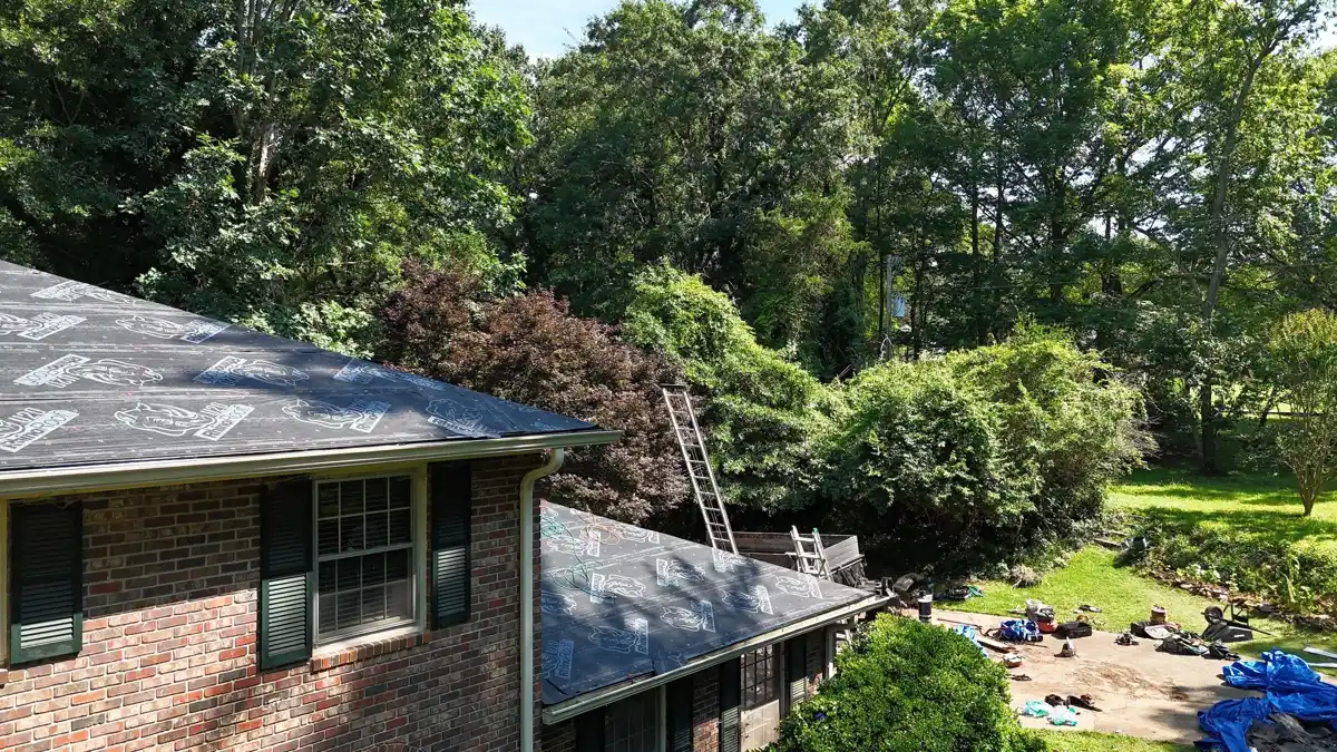Completed shingle roof visible above brick house and screened porch, Southern Premier Roofing work near Stone Mountain GA