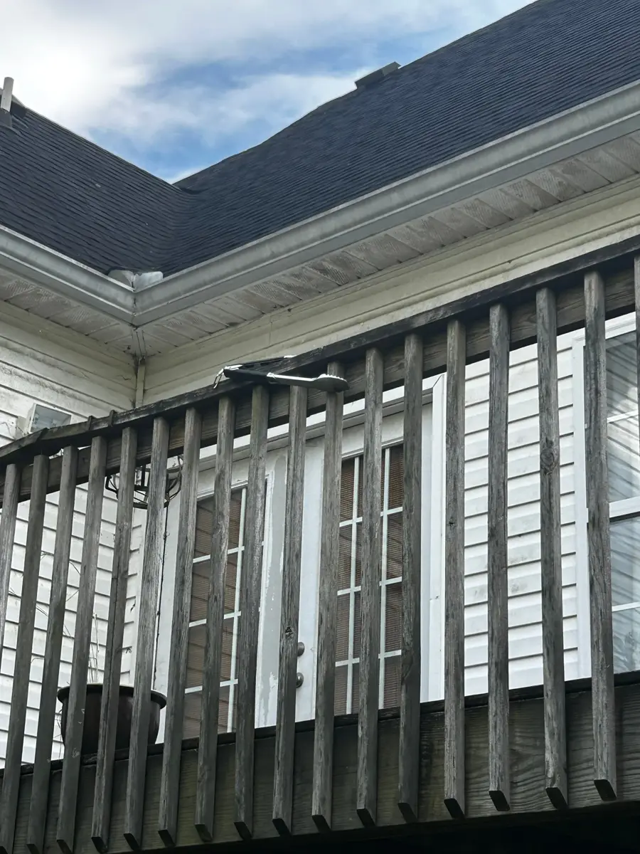 Dark shingle roof sections meet above a screened porch, Southern Premier Roofing work near Suwanee GA