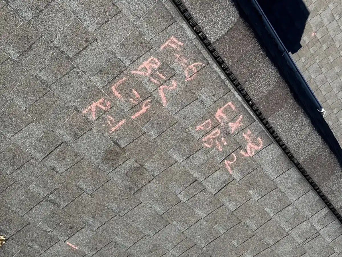 Roof shingles marked with red chalk indicating damaged areas, Southern Premier Roofing work near Walnut Grove GA