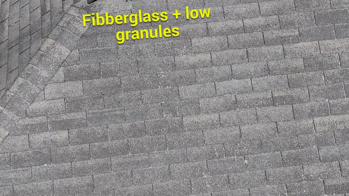 Close view of shingles labeled fiberglass and low granules, Southern Premier Roofing work near Winterville GA