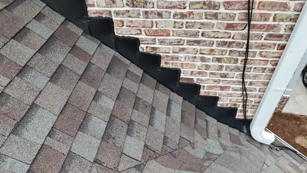 Stepped flashing detail between shingles and brick wall, Southern Premier Roofing work near Winterville GA