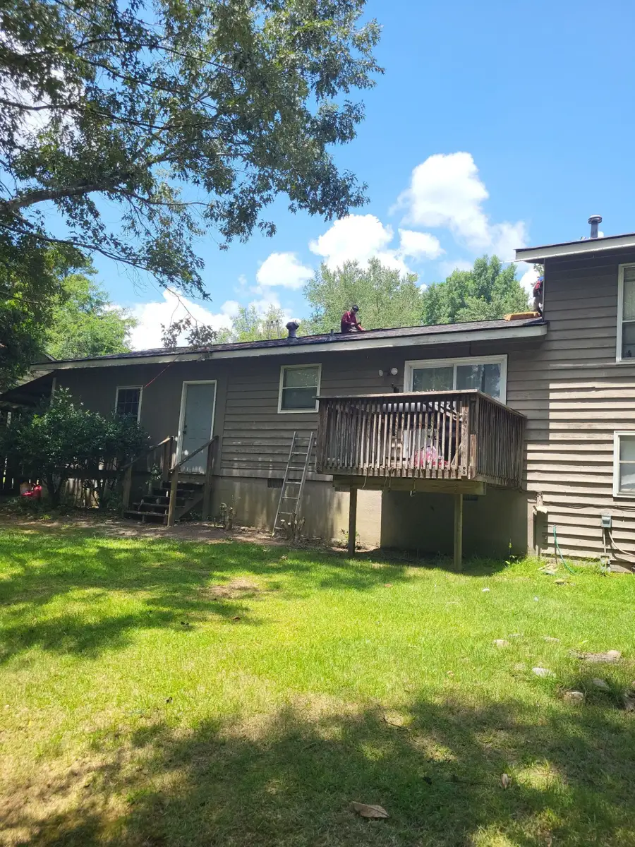 Completed dark shingle roof above backyard deck and siding, Southern Premier Roofing work near Auburn GA