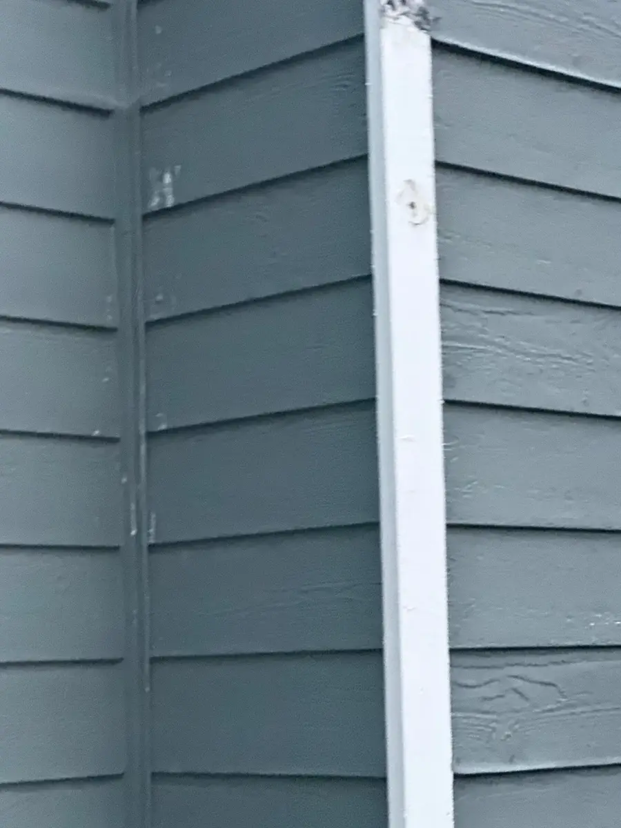 Close view of white vertical exterior trim beside dark siding, Southern Premier Roofing work near Berkeley Lake GA
