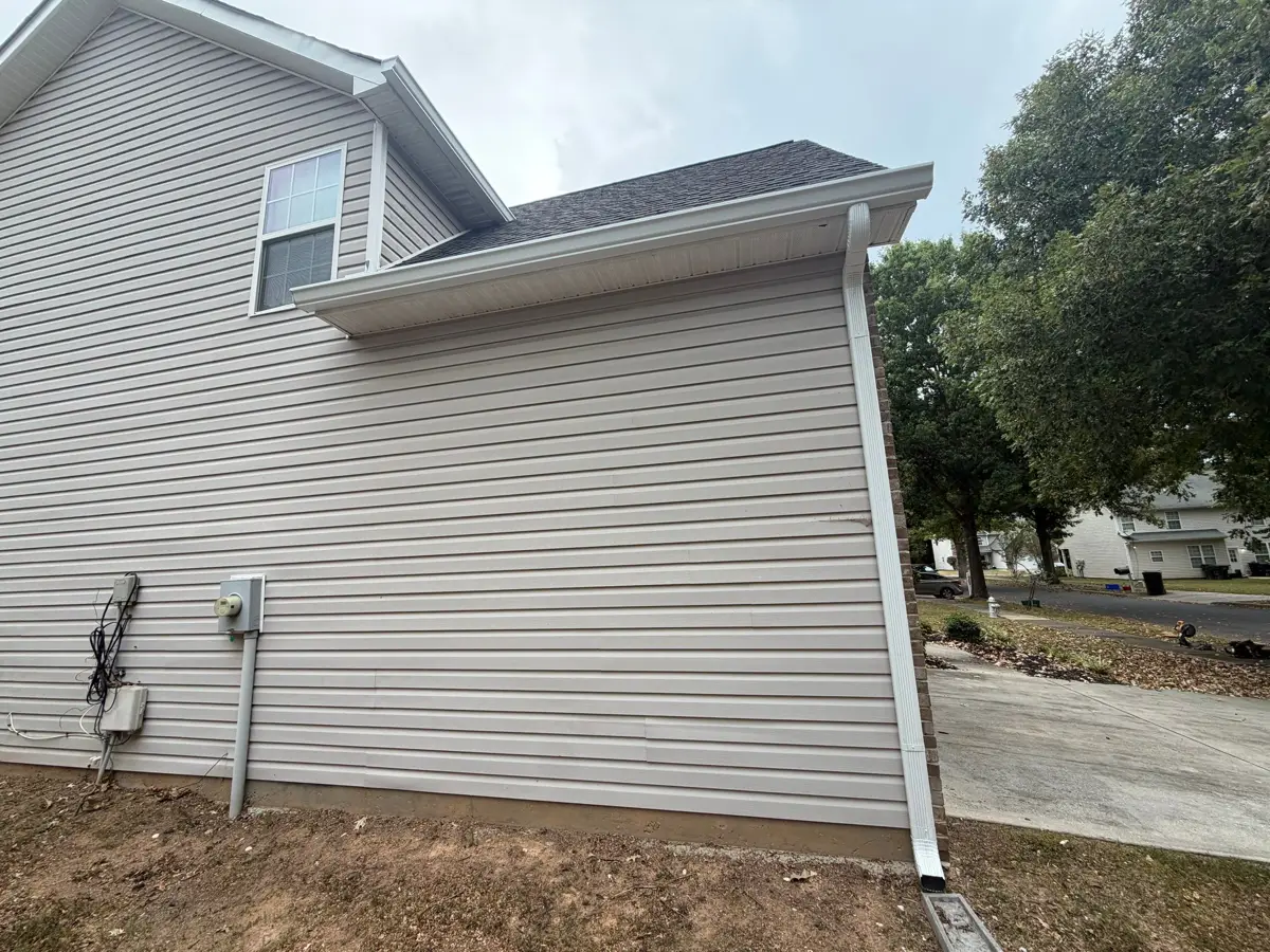 Side view of completed roof edge, siding, downspout, and landscaping, Southern Premier Roofing work near Bethlehem GA