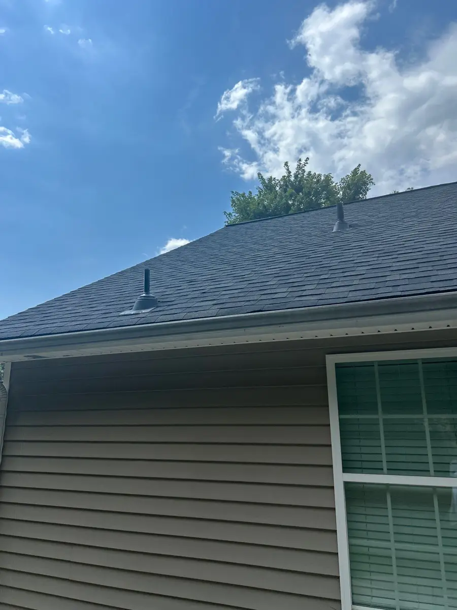 Completed dark shingle roof above siding and large window, Southern Premier Roofing work near Bethlehem GA