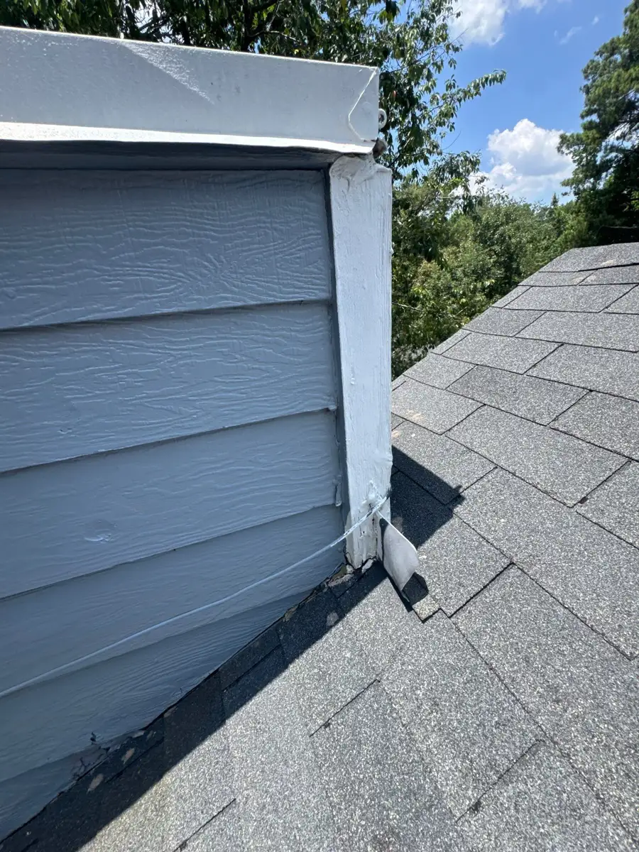 Roof-to-wall flashing beside gray siding and shingles, Southern Premier Roofing work near Braselton GA