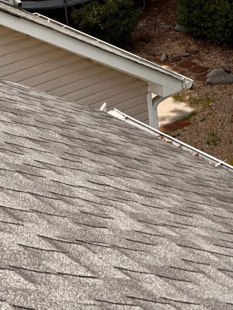 Gray shingle roof above light siding and roof edge, Southern Premier Roofing work near Hoschton GA