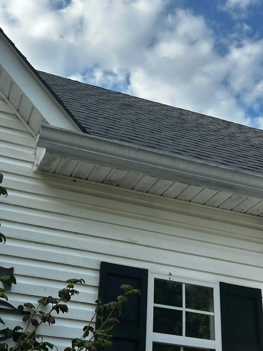 Dark shingled roof above white siding and screened window, Southern Premier Roofing work near Winder GA