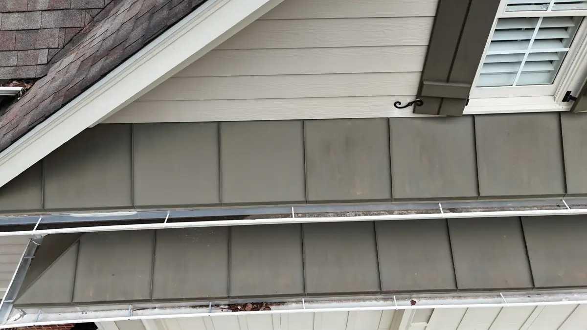Gutter installation along house eave beneath siding and roof edge, Southern Premier Roofing work near Statham GA