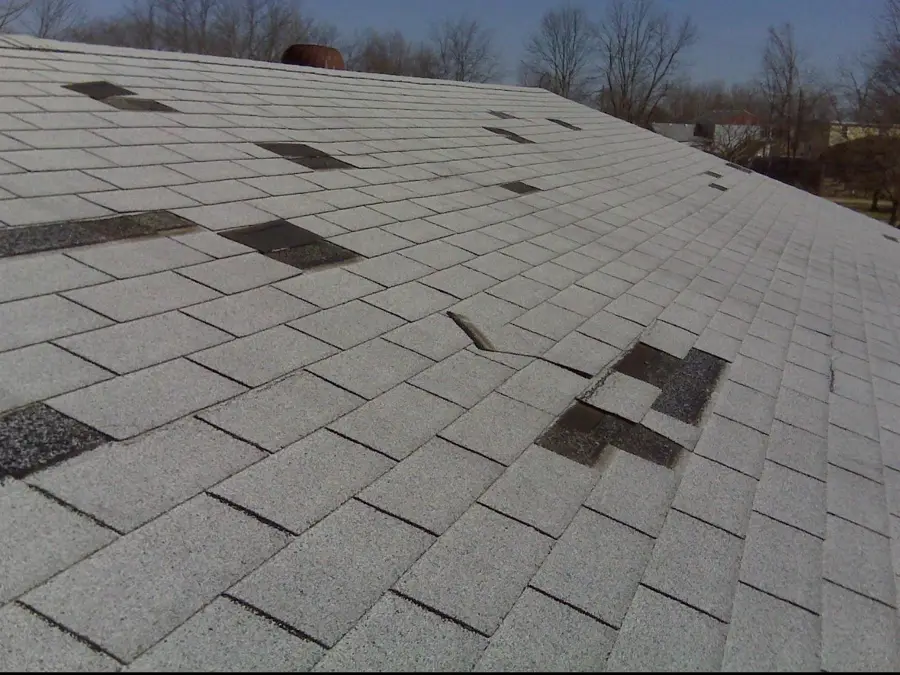 Asphalt shingle roof with missing shingles after a storm